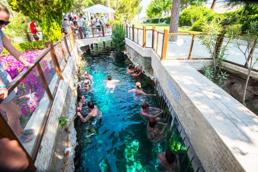 Pammukale, Turkey- July, 2015: Tourists swim in antique Cleopatra pool. Color of water is caused by the presence of a large amount of radon.
