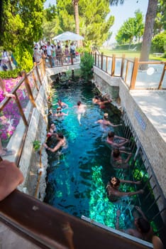 Pammukale, Turkey- July, 2015: Tourists swim in antique Cleopatra pool. Color of water is caused by the presence of a large amount of radon.