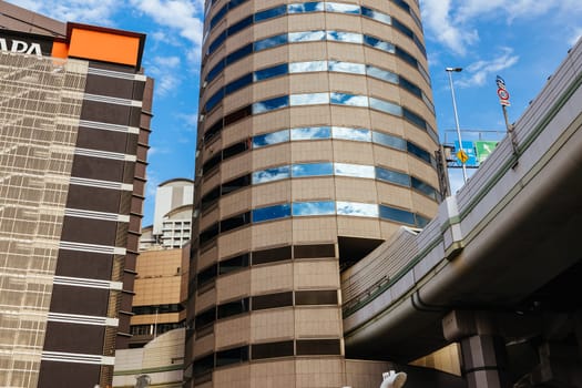 OSAKA, JAPAN - SEPTEMBER 25 2024: The famous 'highway thru a building'. The off ramp for the Umeda Exit of the Ikeda Route of the Hanshin Expressway going thru the Gate Tower Building in Downtown Osaka, Japan