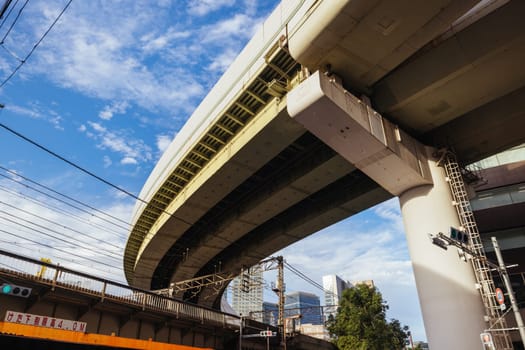 OSAKA, JAPAN - SEPTEMBER 25 2024: The famous 'highway thru a building'. The off ramp for the Umeda Exit of the Ikeda Route of the Hanshin Expressway going thru the Gate Tower Building in Downtown Osaka, Japan