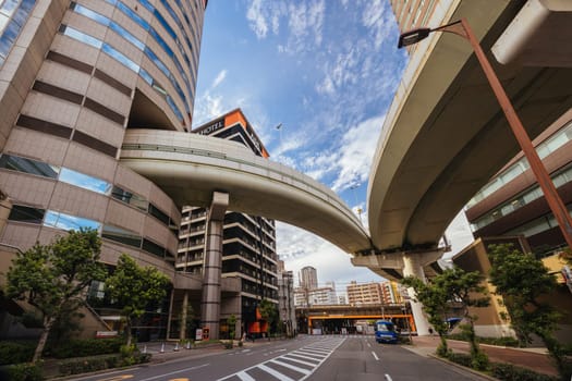 OSAKA, JAPAN - SEPTEMBER 25 2024: The famous 'highway thru a building'. The off ramp for the Umeda Exit of the Ikeda Route of the Hanshin Expressway going thru the Gate Tower Building in Downtown Osaka, Japan