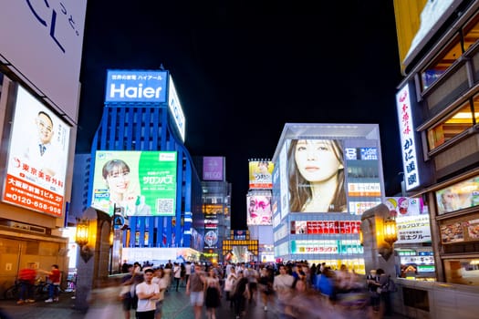 OSAKA, JAPAN - SEPTEMBER 25 2024: The view of the buildings and signage around Ebisubashi Bridge on a clear autumn evening in Osaka, Japan