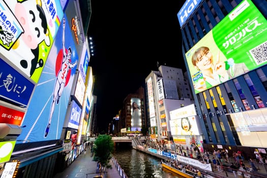 OSAKA, JAPAN - SEPTEMBER 25 2024: The view of the buildings and signage around Ebisubashi Bridge on a clear autumn evening in Osaka, Japan