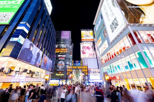 OSAKA, JAPAN - SEPTEMBER 25 2024: The view of the buildings and signage around Ebisubashi Bridge on a clear autumn evening in Osaka, Japan