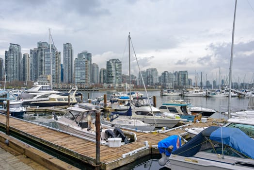 Yachts and boats moored at the pier in downtown of Vancouver, Canada.