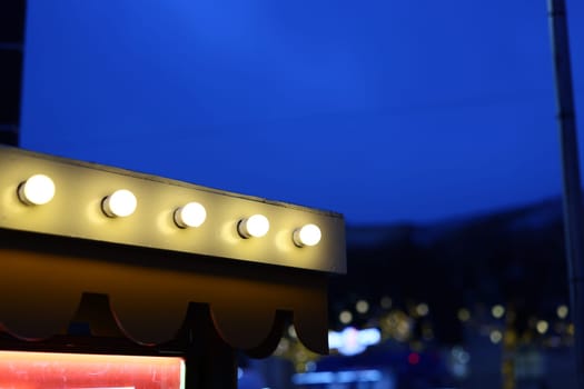 Warm light bulbs brilliantly shine against a mesmerizing twilight blue sky, crafting a truly welcoming atmosphere