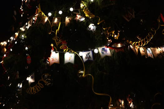 A beautifully lit Christmas tree, adorned with colorful lights and festive photos, spreading joy and happiness