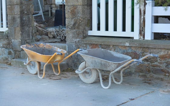Construction wheelbarrows standing at a building site.