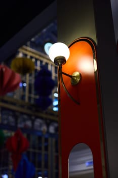 A beautifully designed and stylish wall sconce that illuminates a vibrant interior space full of colorful elements