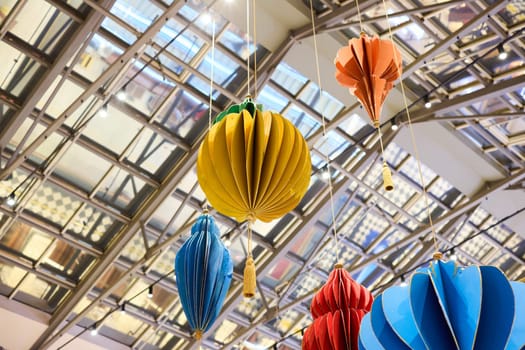 Vibrant paper decorations that are suspended from a ceiling create a truly playful and inviting atmosphere