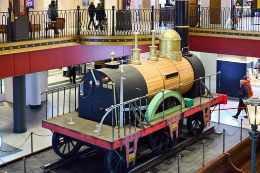 A breathtaking antique steam locomotive is beautifully showcased within a contemporary museum environment