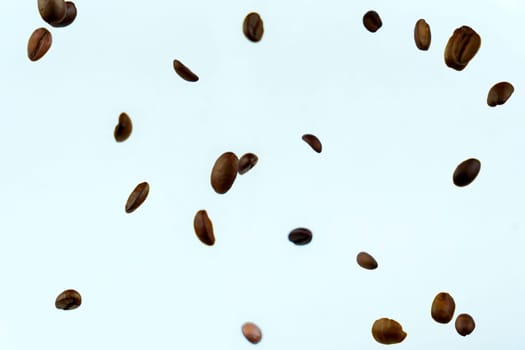 Roasted coffee beans captured in mid-air against a light background, creating a minimalistic and dynamic composition with scattered arrangement.