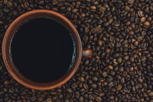 A ceramic cup filled with black coffee, surrounded by roasted coffee beans in a warm, cozy setting. Perfect for illustrating coffee culture and aroma.