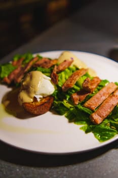 Gourmet Caesar salad with grilled chicken and dressing on a white plate in a cafe and roaster