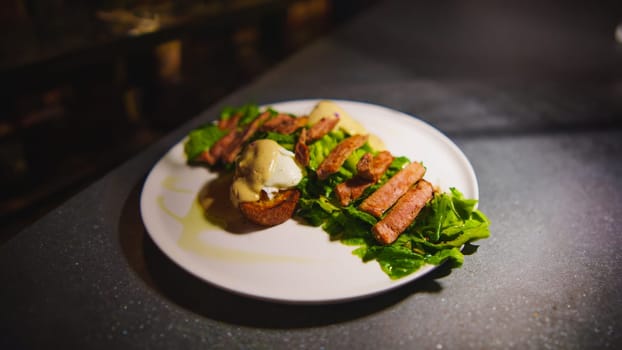 Gourmet steak on a bed of greens served on a white plate, with elegant dark background in the cafe