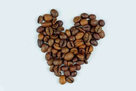 Roasted coffee beans neatly arranged in the shape of a heart on a clean white background, symbolizing love for coffee in a simple design.