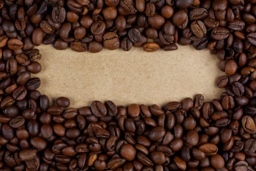Roasted coffee beans creating a natural frame around a blank kraft paper area, ideal for adding text or design elements, rustic and organic, no people.