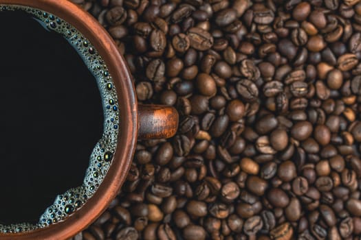 Close-up of a ceramic cup partially filled with black coffee, surrounded by roasted coffee beans, showcasing the rich texture and aroma.