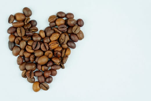 A neat arrangement of roasted coffee beans in the shape of a heart on a clean white background, symbolizing love for coffee.