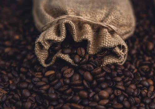 A close-up of a burlap sack spilling roasted coffee beans onto a pile, showcasing texture and richness with a rustic ambiance.