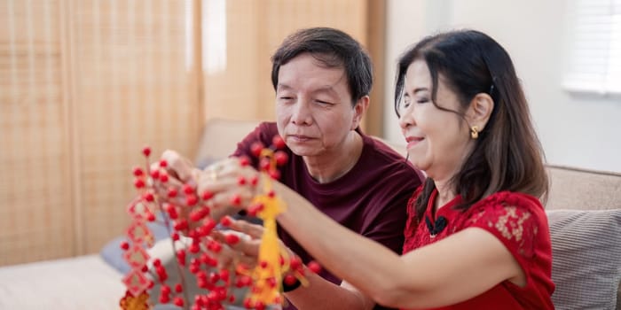 An elderly Chinese couple shares joyful moments while preparing for the New Year celebrating their love and traditions.
