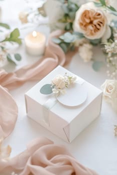 Pastel-colored circular sticker with elegant cursive typography on a white gift box. surrounded by delicate wrapping props and pale pink ribbon, creating a luxurious and sophisticated gift presentation perfect for special occasions.