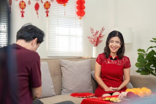 A joyous gathering as a granddaughter shares heartfelt moments with her grandparents during Chinese New Year celebrations.