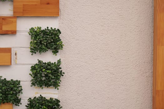 This contemporary wall design features artificial greenery and wooden accents for a unique ambiance
