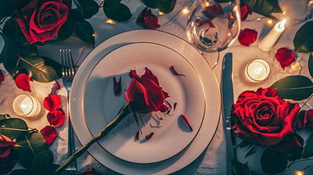 Festive table setting with candles and arrangement of beautiful red flowers. Holiday concept. High quality photo