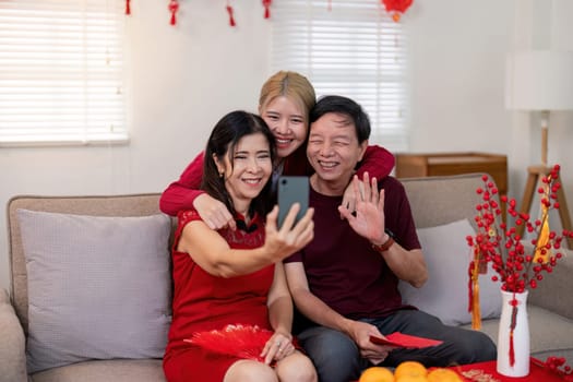 A joyful family capturing memories during Chinese New Year with grandparents and granddaughter celebrating together.