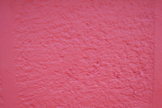 A vibrant pink wall with a textured, rough surface for dynamic, captivating visuals