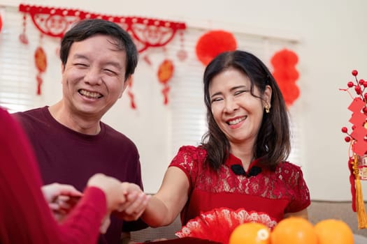 A joyous family gathering celebrating Chinese New Year highlighting the love between grandparents and their granddaughter.