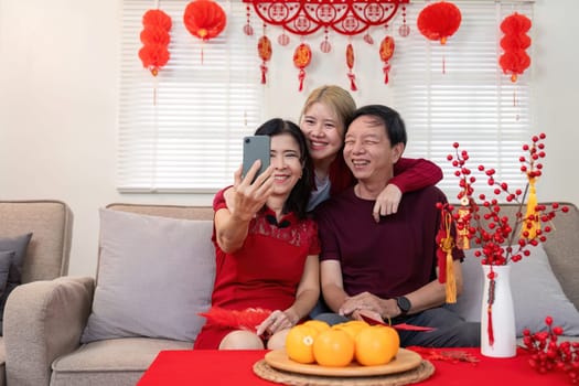 Three generations share joy during Chinese New Year celebrations capturing memories in a vibrant home setting.