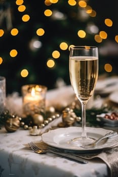 High angle of christmas table with glass of cocktail with champagne, blurred christmas tree on background. AI Generated