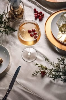 High angle of christmas table with glass of cocktail with champagne, blurred christmas tree on background. AI Generated