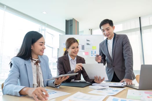 Business People Meeting using laptop computer,calculator,notebook,stock market chart paper for analysis Plans to improve quality next month. Conference Discussion Corporate Concept..