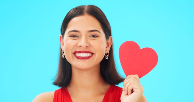 Portrait, happy and woman with paper heart in studio isolated on a blue background mockup space. Face smile, romance and model with love sign for anniversary symbol, emoji and care on valentines day.