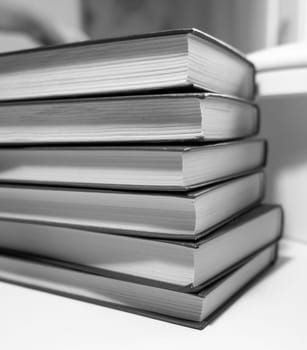 Stack of books on a white background. One book is yellow. Book reading and learning concept.