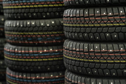 Sale of car tires for sale in the store. Many new winter tires lie horizontally. There is space for text