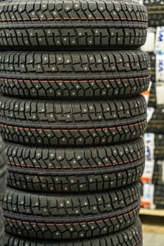 Sale of car tires for sale in the store. Many new winter tires lie horizontally. There is space for text