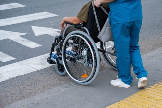 A faceless nurse pushes an elderly woman in a wheelchair across the road
