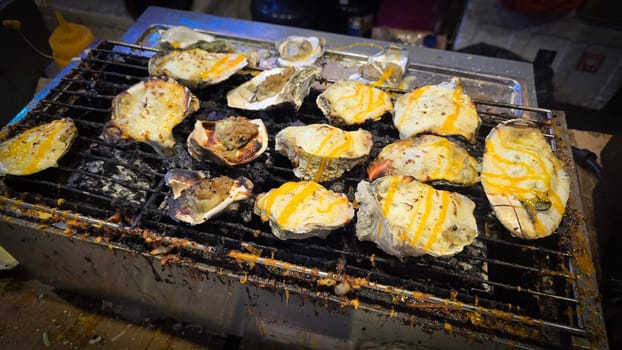 street vendor uses a torch flame to prepare delicious grilled oyster with flair and skill, showcasing the vibrant atmosphere of bustling night Thai markets. Good for recipe book