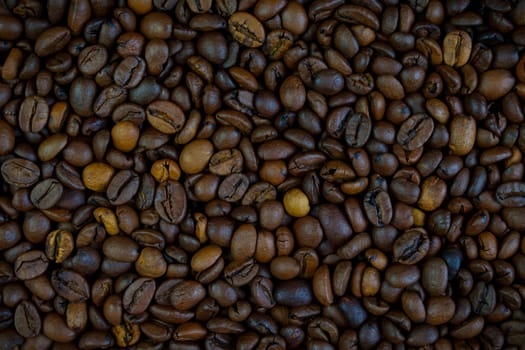 Detailed close-up of roasted coffee beans showcasing rich brown tones and natural textures, perfect for culinary and beverage concepts, no people.