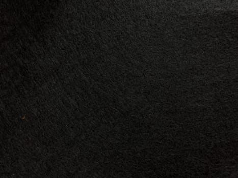 Dark textured surface background with subtle patterns and shadows.