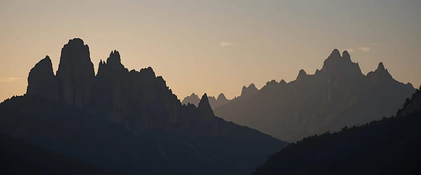 Jagged silhouettes dance against the dimming sky, whispering tales of ancient majesty. Twilight's gentle embrace casts a serene hush, awakening a profound sense of solitude and awe.