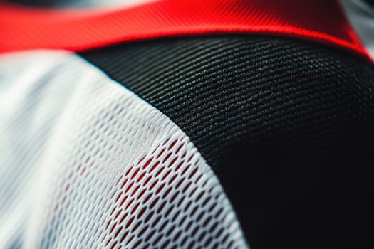 Close-up view focused on the sleeve area of a sports jersey, showcasing precise stitching and logo placement. the blurred studio background highlights the texture and design elements, bringing attention to the garments craftsmanship.