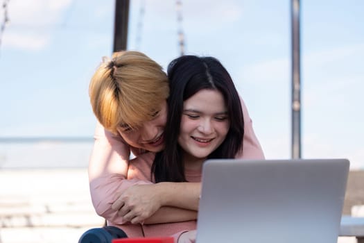 A couple shares a joyful moment while connecting online in a romantic outdoor setting for Valentine Day.