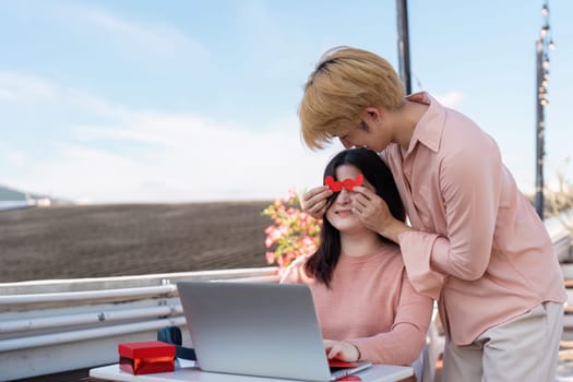 A couple shares a sweet moment at their beachside workspace with playful surprises embodying the spirit of Valentine Day.