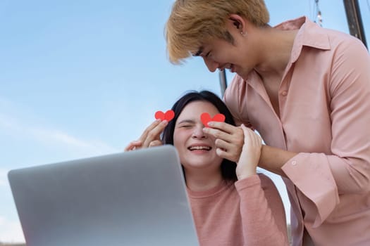 A couple shares a joyful moment during Valentine Day showcasing love through playful interaction and digital connection.
