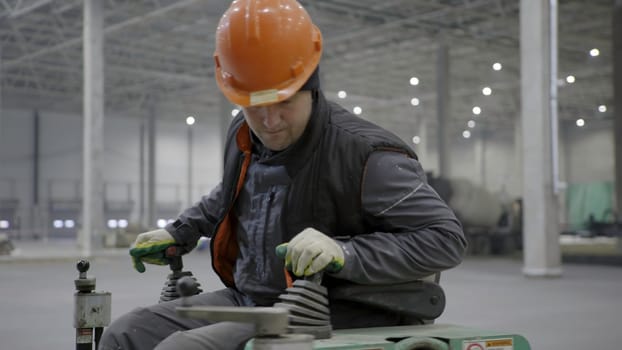 A skilled worker expertly operates heavy machinery in an industrial space, emphasizing safety and expertise. Clip